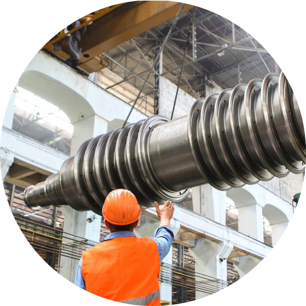 A man directing a crane operator moving a large piece of metal.